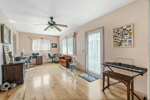 interior space featuring ceiling fan, a textured ceiling, and light wood-type flooring