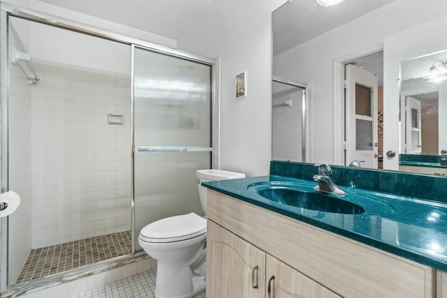 bathroom with vanity, toilet, a shower with shower door, and tile patterned flooring