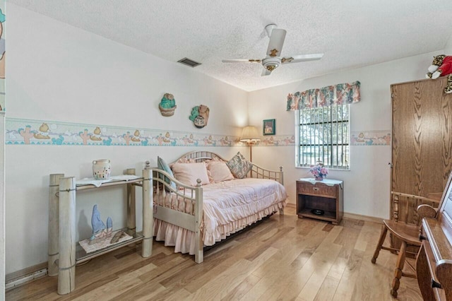 bedroom featuring wood-type flooring, ceiling fan, and a textured ceiling