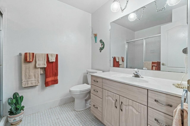 bathroom with tile patterned flooring, vanity, an enclosed shower, and toilet