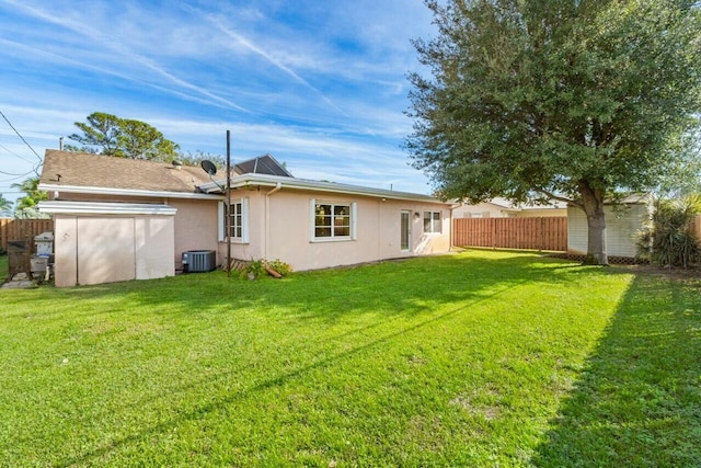 rear view of property featuring a shed, central AC unit, and a yard