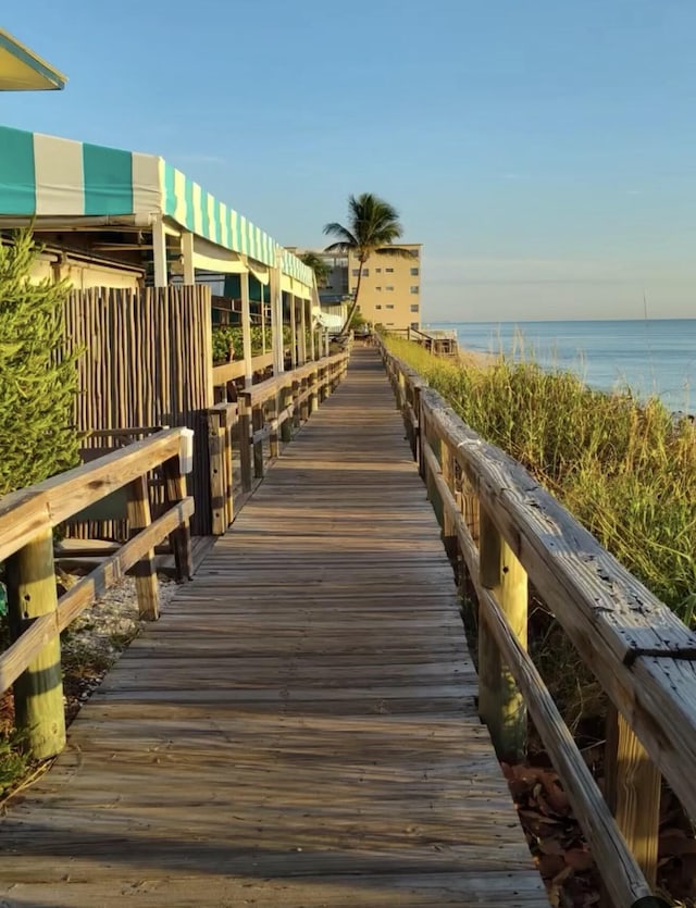 view of dock with a water view and a view of the beach