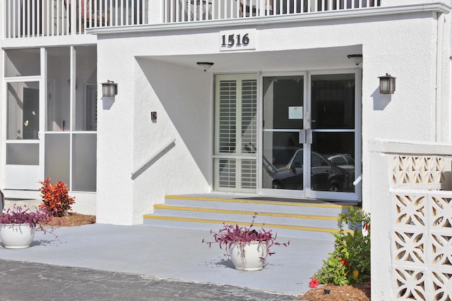 view of exterior entry featuring a balcony