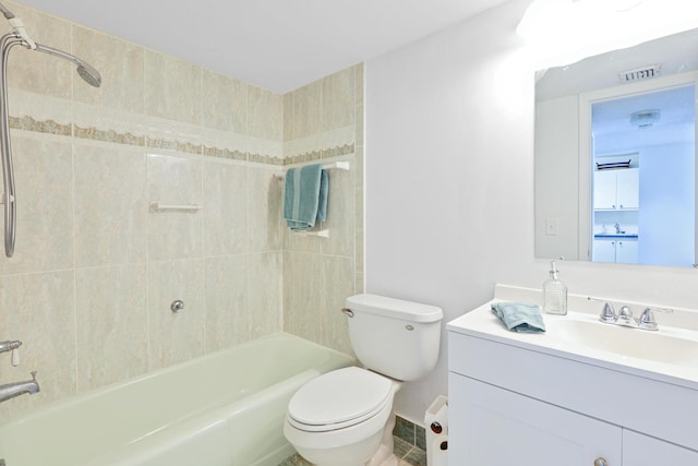 full bathroom featuring tiled shower / bath, vanity, and toilet