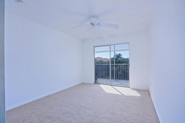 carpeted spare room featuring ceiling fan and a textured ceiling