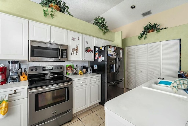 kitchen featuring white cabinetry, tasteful backsplash, stainless steel appliances, and light tile patterned flooring