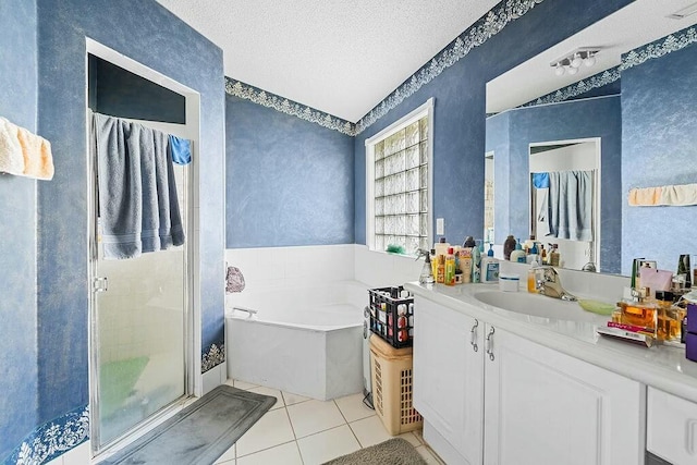 bathroom with tile patterned floors, separate shower and tub, vanity, and a textured ceiling