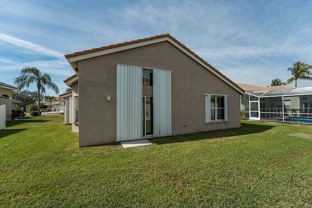 rear view of house with a lanai and a lawn