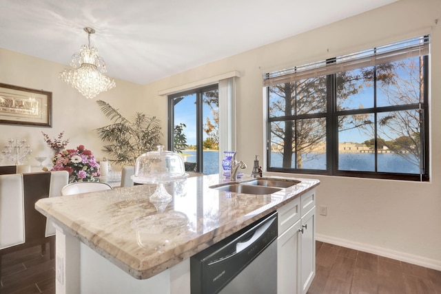 kitchen with pendant lighting, an island with sink, white cabinets, stainless steel dishwasher, and a water view