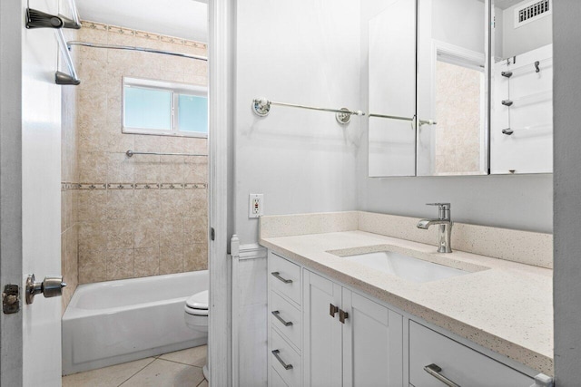 full bathroom with tiled shower / bath combo, vanity, tile patterned floors, and toilet