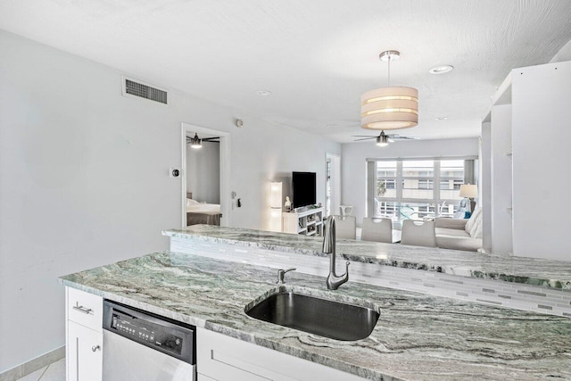 kitchen featuring sink, dishwasher, light stone counters, white cabinets, and decorative light fixtures