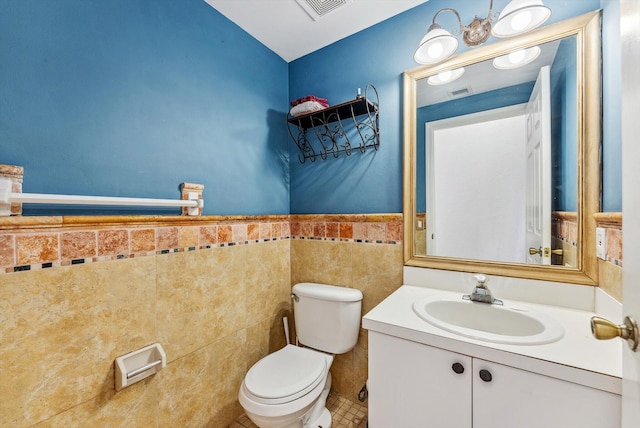 bathroom with toilet, tile walls, and vanity