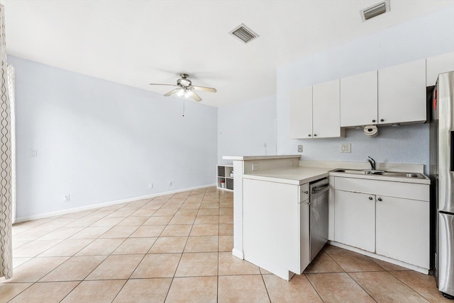 kitchen with kitchen peninsula, sink, dishwasher, light tile patterned floors, and white cabinets