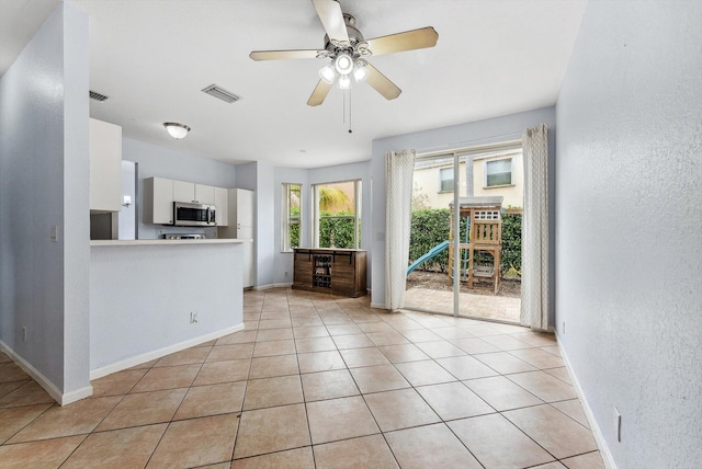 interior space featuring light tile patterned floors and ceiling fan