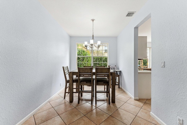 dining room with light tile patterned flooring and an inviting chandelier