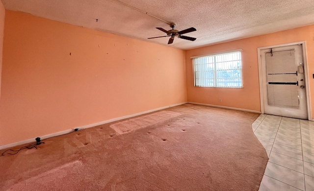 carpeted spare room featuring ceiling fan and a textured ceiling