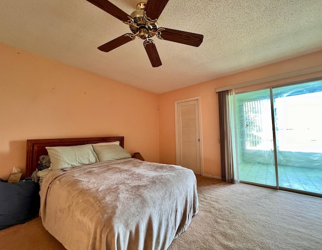 bedroom with ceiling fan, carpet flooring, access to exterior, and a textured ceiling