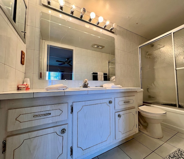 full bathroom with tile walls, vanity, tile patterned flooring, and combined bath / shower with glass door