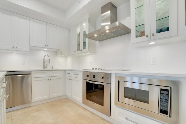 kitchen with sink, appliances with stainless steel finishes, tasteful backsplash, white cabinets, and exhaust hood