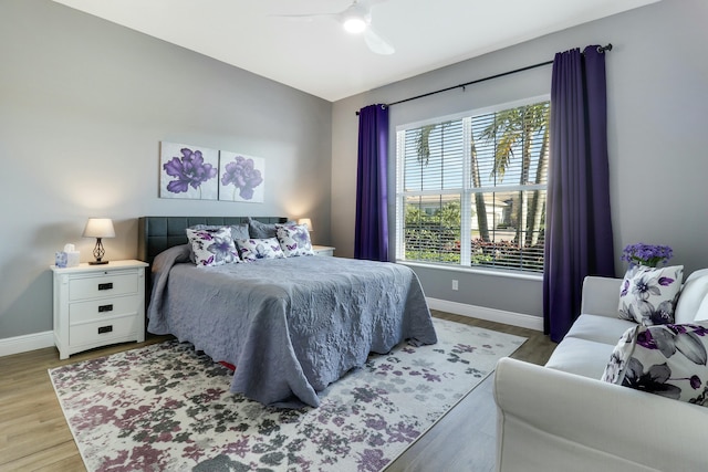 bedroom featuring ceiling fan, baseboards, and light wood-style flooring