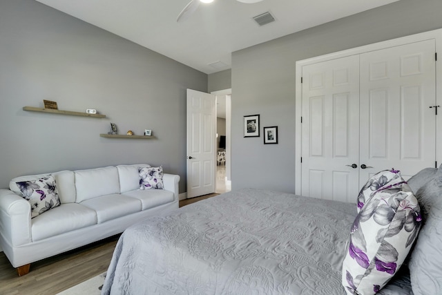 bedroom featuring a closet, visible vents, ceiling fan, and wood finished floors