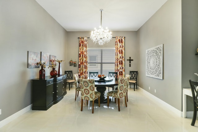 dining area featuring a chandelier, light tile patterned floors, and baseboards