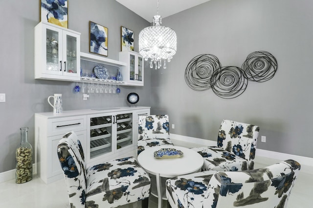 dining area featuring baseboards, a bar, and a chandelier