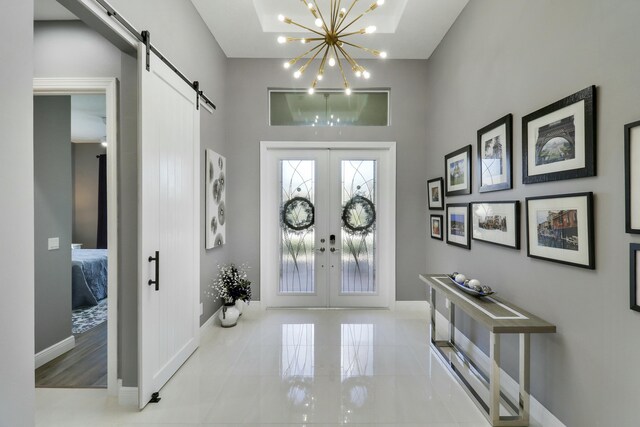 entryway featuring a barn door, an inviting chandelier, and french doors