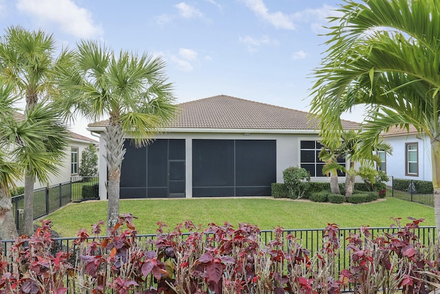 rear view of property with a tile roof, a yard, a fenced backyard, and stucco siding