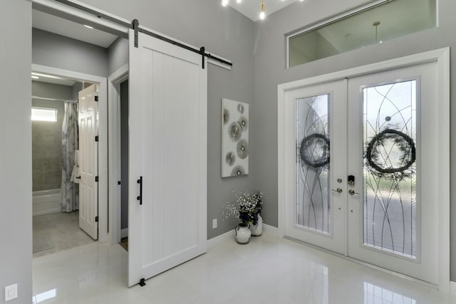 foyer with a barn door, baseboards, and french doors