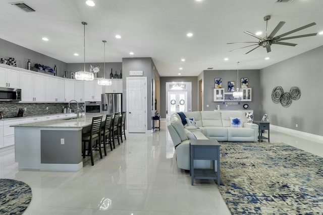 living room with recessed lighting, visible vents, and baseboards