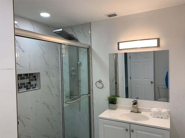 bathroom featuring vanity, toilet, and walk in shower