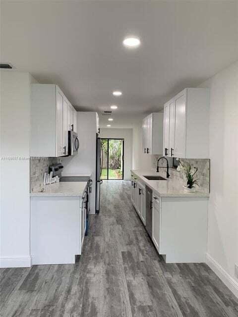 kitchen featuring appliances with stainless steel finishes, sink, white cabinets, and backsplash