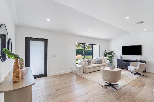 living room featuring vaulted ceiling and light hardwood / wood-style floors