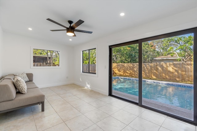 unfurnished room featuring lofted ceiling, ceiling fan, and light tile patterned flooring