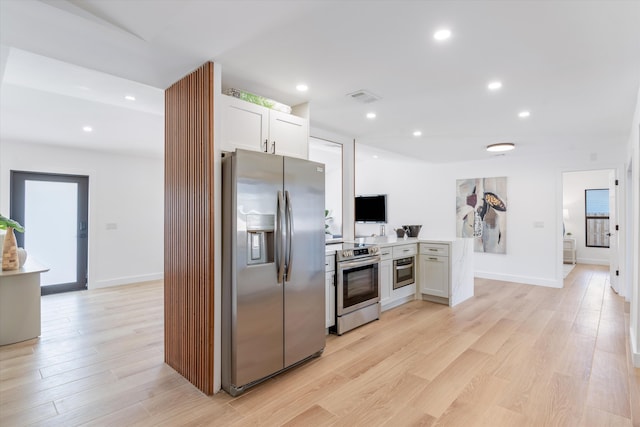 kitchen featuring appliances with stainless steel finishes, light hardwood / wood-style floors, kitchen peninsula, and white cabinets