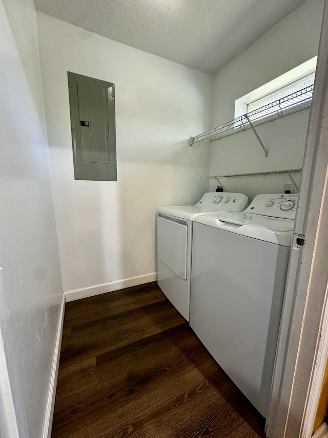 washroom with washing machine and dryer, dark wood-type flooring, electric panel, and a textured ceiling