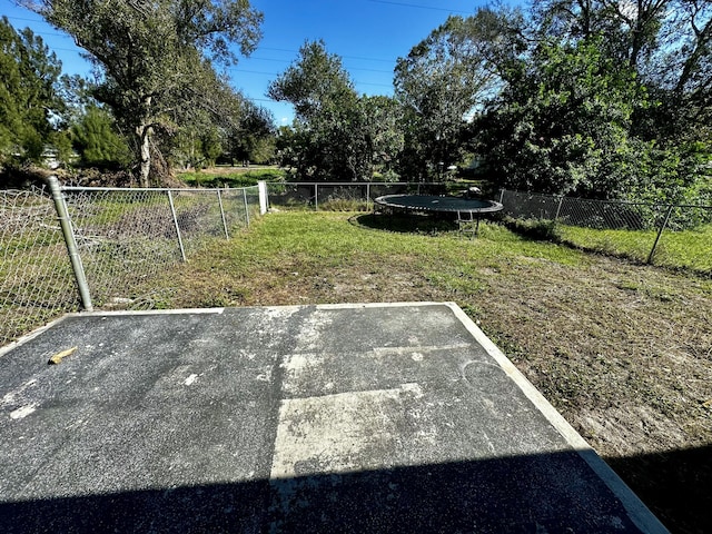 view of yard featuring a patio and a trampoline