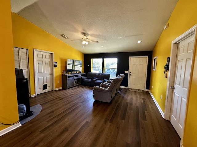 living room with dark wood-type flooring, ceiling fan, lofted ceiling, and a textured ceiling