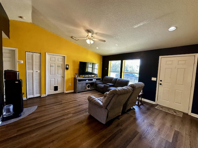 living room featuring dark wood-type flooring, ceiling fan, lofted ceiling, and a textured ceiling