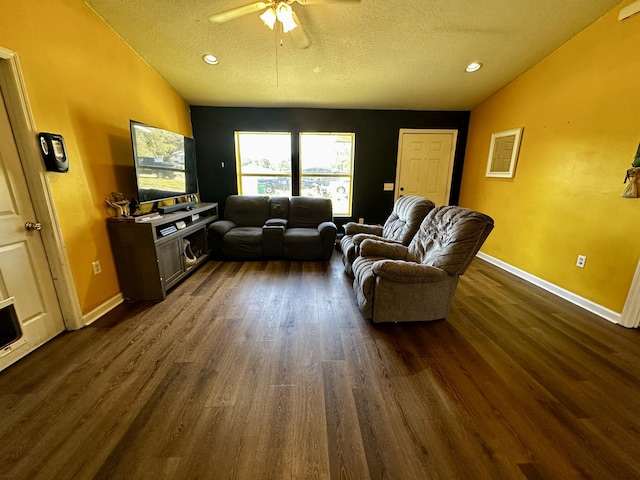 living room with ceiling fan, a textured ceiling, and dark hardwood / wood-style flooring