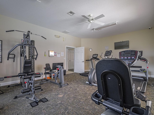 workout area featuring ceiling fan and a textured ceiling