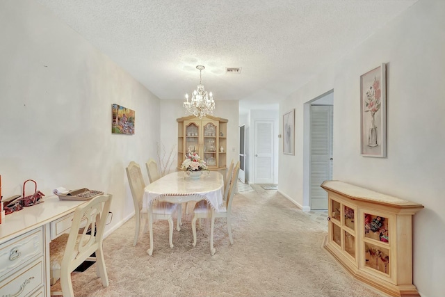 carpeted dining area with a textured ceiling and a notable chandelier