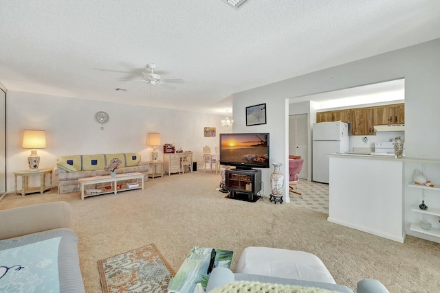 carpeted living room featuring ceiling fan and a textured ceiling