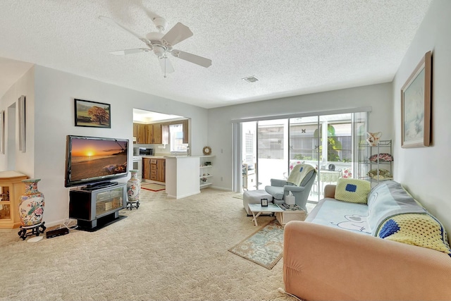 carpeted living room featuring a textured ceiling, plenty of natural light, and ceiling fan