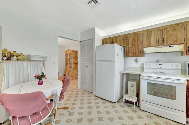 kitchen featuring a textured ceiling and white appliances