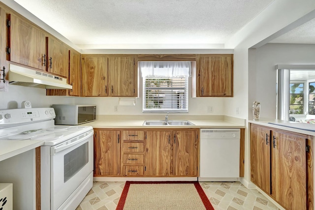 kitchen with white appliances, sink, and a textured ceiling