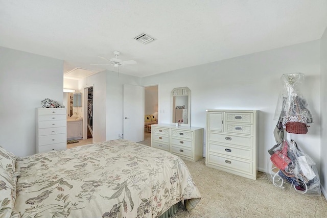 carpeted bedroom with ensuite bath and ceiling fan