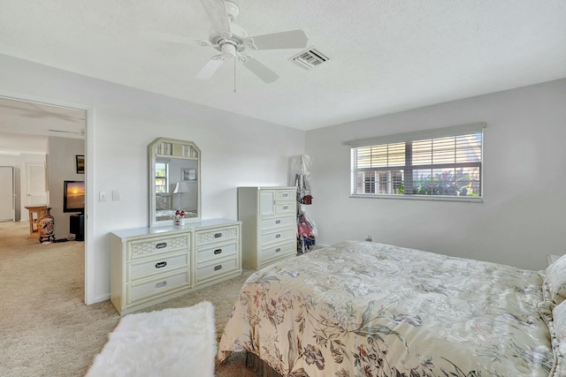 carpeted bedroom with a textured ceiling and ceiling fan