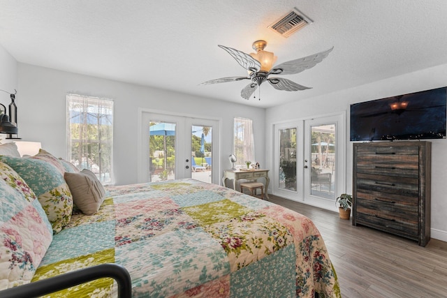 bedroom featuring access to exterior, french doors, visible vents, and wood finished floors